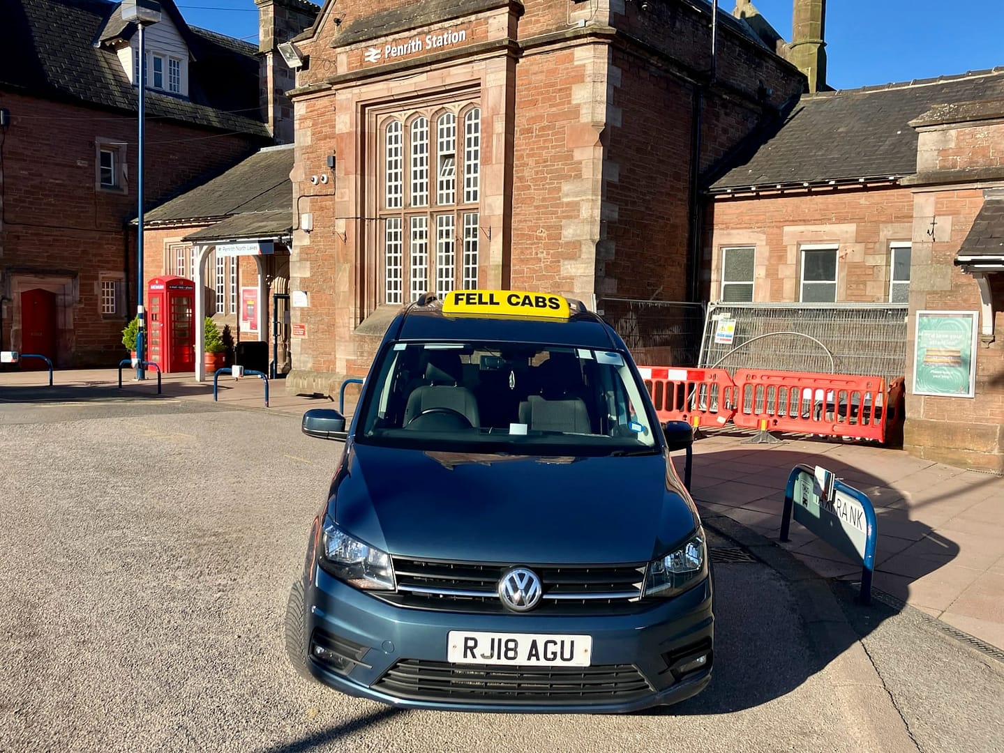 Fell Cabs parked on a sunny day in front of Penrith Railway Station in the Lake District